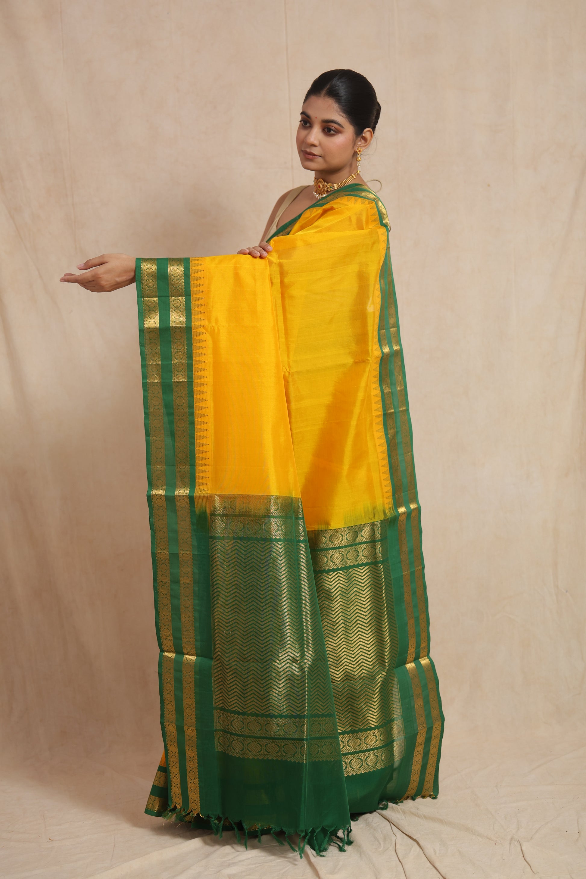 Pallu display of yellow Kanchipuram Sico saree with green woven border