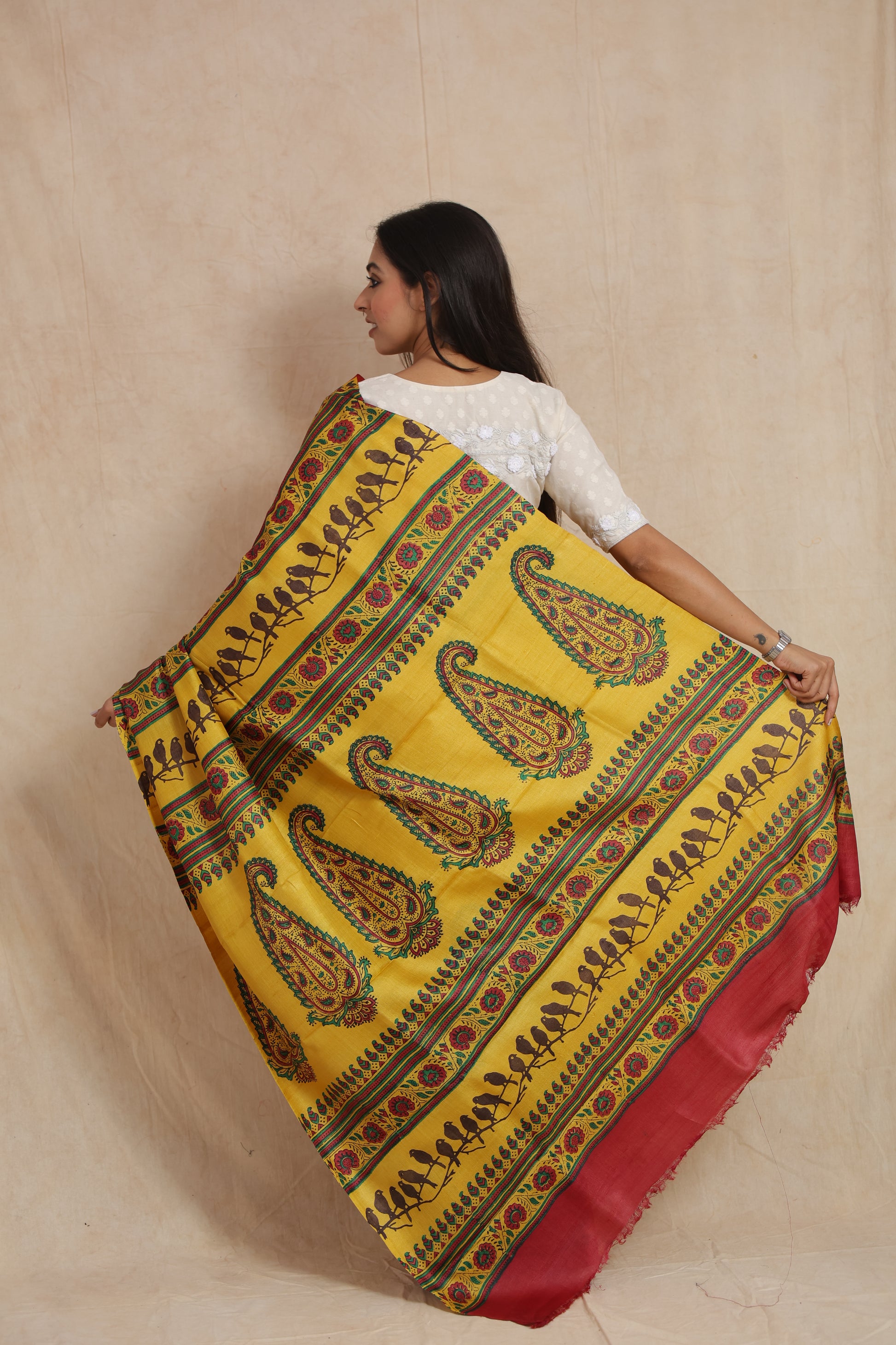Back pallu view of sunshine yellow printed Tussar saree with paisley and bird motifs